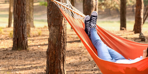 Woman relaxing in hammock outdoors