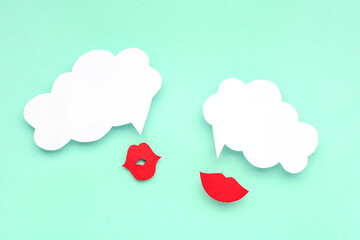 Paper lips with blank speech bubbles on turquoise background
