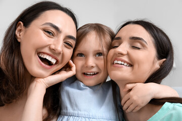 Young lesbian couple with adopted little girl at home, closeup