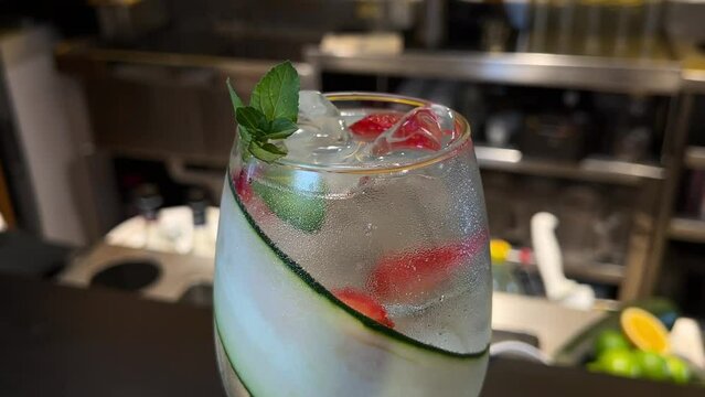fresh gin tonic with cucumber pieces of fresh strawberry ready to be enjoyed