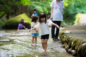 渓流で水遊びする姉妹