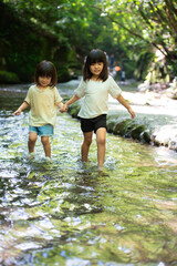 渓流で水遊びする姉妹