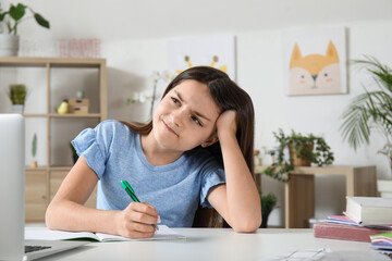 Obraz na płótnie Canvas Upset little girl doing lessons at home