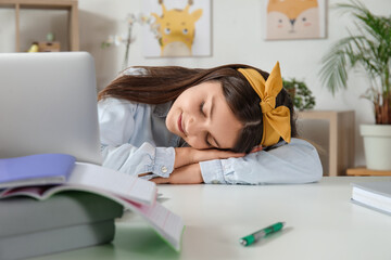 Little girl sleeping while doing lessons at home