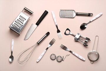 Set of different kitchen utensils on beige background
