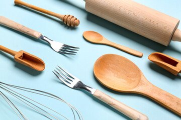 Set of wooden kitchen utensils on blue background