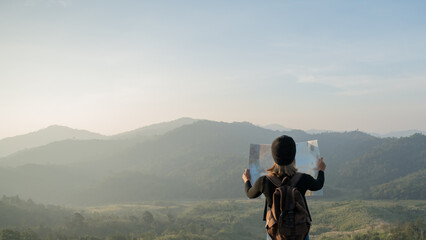 Adventurous girl navigating in with a topographic map in beautiful mountains of thailand. woman wearing hat stand alone and enjoying freedom and calm inspired travelling on background view mockup.