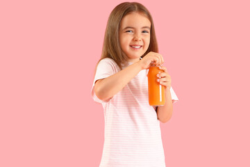 Cute little girl with bottle of orange juice on color background