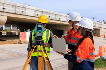 Engineer use theodolite equipment and looking blueprints  project on laptop for route surveying to...