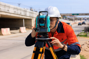 engineer use theodolite equipment  for route surveying to build a bridge across the intersection to...