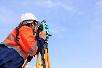 engineer use theodolite equipment  for route surveying to build a bridge across the intersection to...
