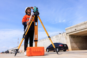 engineer use theodolite equipment  for route surveying to build a bridge across the intersection to...
