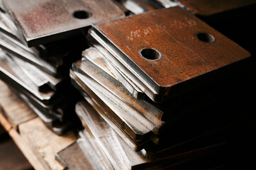 Stacks of metal plates with holes in plant storehouse