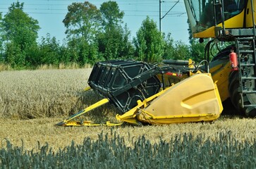 combine harvester machine  at work in dusty field farm