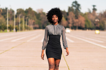 mujer afroamericana con expresión seria caminando por las calles, haciendo poses, modelando al...