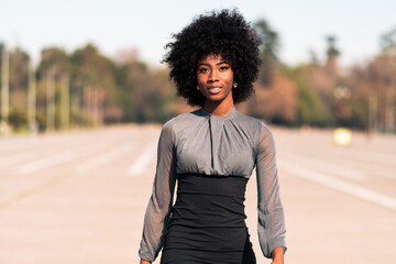 mujer afroamericana sonriente caminando por las calles, haciendo poses, modelando al aire libre con minifalda