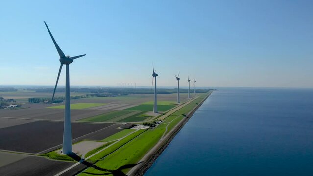 Wind mill turbines park with clouds and a blue sky, windmill park in the ocean aerial view with wind turbine Flevoland Netherlands Ijsselmeer. Green Energy production in the Netherlands