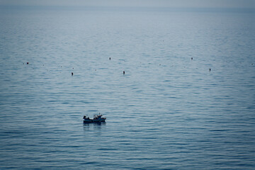 a small boat fishing on the sea