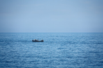 a small boat fishing on the sea