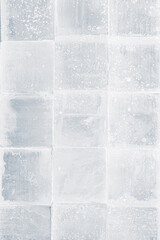 Textured frosty crystal square translucent ice blocks pattern background.
