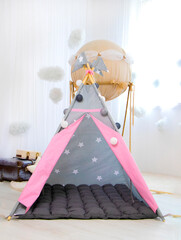 Playroom with Teepee. Modern room interior with play tent for child. pink children's wigwam in the room on the floor Scandinavian style with decor. High quality photo © Nataliia