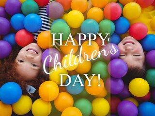 Composition of happy children's day text and biracial children smiling lying in colourful balls - Powered by Adobe