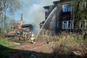 Obraz premium extinguishing the fire of a wooden house