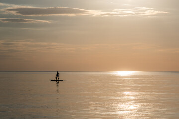 sunset on the sea with surfer