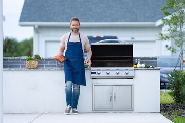 photo of positive man cook seafood barbecue with fish. man cook seafood barbecue.