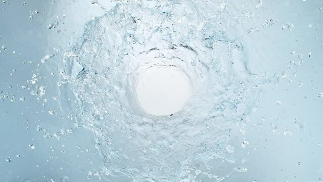 Super Slow Motion Shot of Round Water Splash on Light Blue Background at 1000fps.