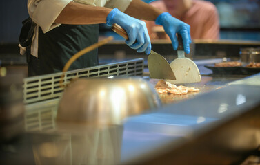 Japanese deliberately cuisine chef cooking work at the hot table, Show your cooking skills to customers, Includes condiments meat and vegetables.grill, Japanese teppanyaki restaurant.