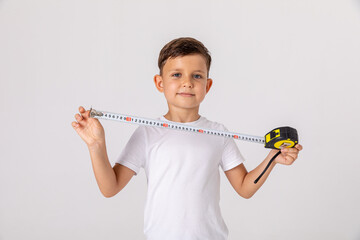 Daddy's little helper. Happy baby boy construction worker holding measuring tape and smiling while...