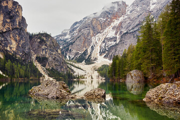 mountain lake with overcast sky and mountains in the background in the morning