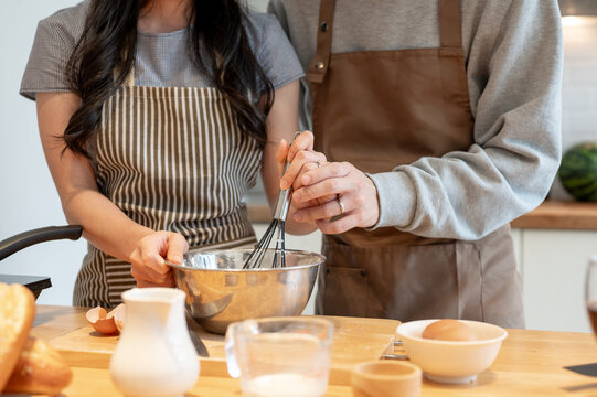 Close-up image of a couple is having a cooking date at home, and enjoying making pancakes