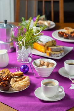  Coffee table setting with white tableware in Christmas style on a table with a purple tablecloth. Merry Christmas concept. Receiving guests,