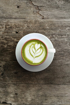A cup of green tea matcha latte on wooden background                                                                                                                                                    