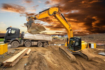 excavator is in work and digging at construction site - obrazy, fototapety, plakaty