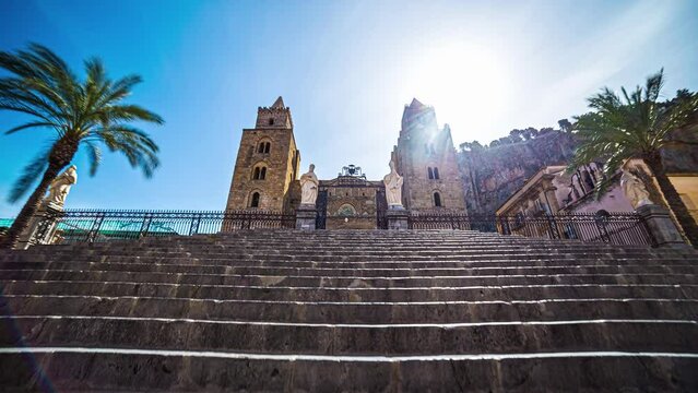 Low angle shot of locals and tourists entering and leaving Cefal&ugrave; Cathedral in timelapse in Sicily, southern Italy on a sunny summer day.