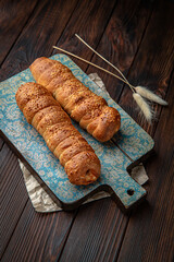 Sausage in dough, meat bun on brown boards. For decoration of bakery sales outlets. Bakery products. Fresh bakery.