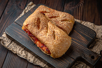 Lush puff with meat, vechina, mushrooms, potatoes on brown boards. For decoration of bakery sales outlets. Bakery products. Fresh bakery.