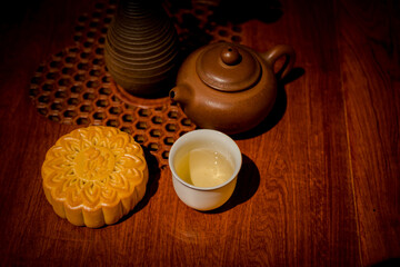 Mooncake for Mid-Autumn Festival, concept of traditional festive chinese food on an Asian wooden tray with teapot.