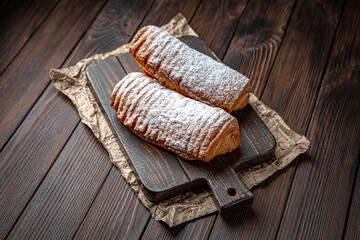 Fluffy puff pastry bun with apple, berries, pumpkin, or sweet cottage cheese on brown boards. Bakery products. Fresh bakery.