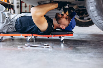 Car mechanic doing car check up under the auto
