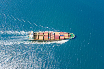 Loaded container ship cruising open ocean sea for logistics import export, aerial shot