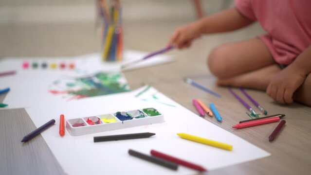 
Close up shots paint brushes of Little cute girl creating and water color painting activity in living room at home. Kids activity. Child physical, Emotional, Cognitive development concept.