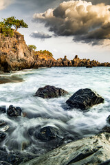 Obraz premium Exclusive beach of Tenerife. Beautiful sunset by the Atlantic Ocean. Epic volcanic rocks, cliffs, black sand, waves, turquoise water. Premium landscape from pure nature, town Alcalá, Canary Islands 