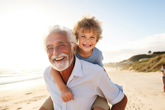 Happy grandfather joyfully piggybacking his cute little grandson on the beach