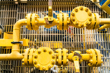 Small yellow valves placed next to each other control the flow of outdoor oil pipelines.