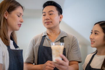 Barista workers are tasting coffee drinks at the counter pantry of coffee. Man and women enjoy...