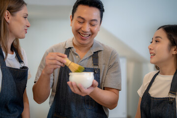 Barista workers are tasting green tea matcha drinks at the counter pantry of cafe. Man and women...